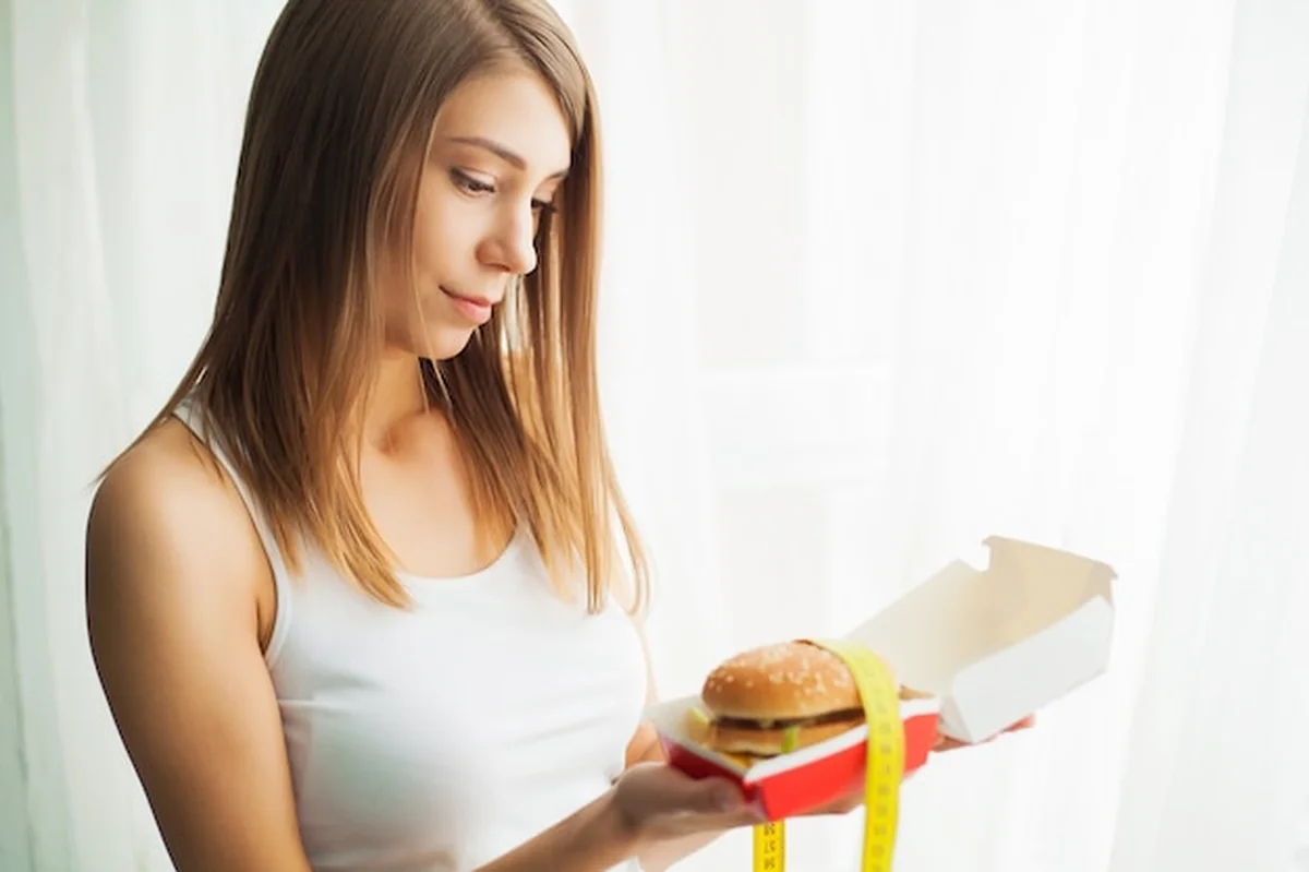 Młoda kobieta unika fast foodów
