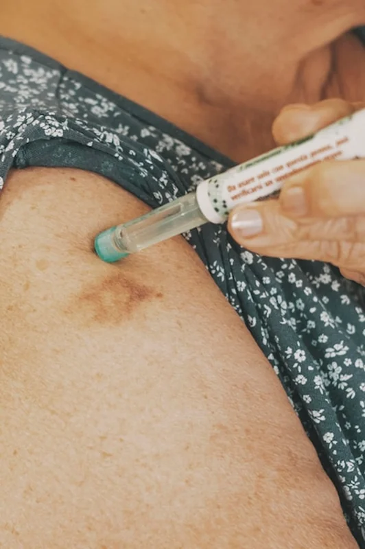 Starsza kobieta przyjmuje insulinę za pomocą strzykawki