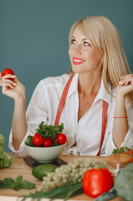 Piękna i sportowa dziewczyna w kuchni z warzywami