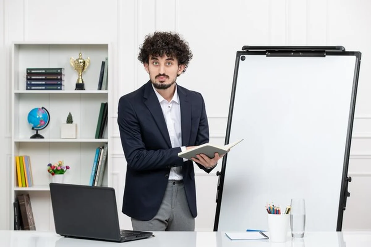 Nauczycielka brunetka z komputerem i tablicą w klasie wyjaśnia wykład