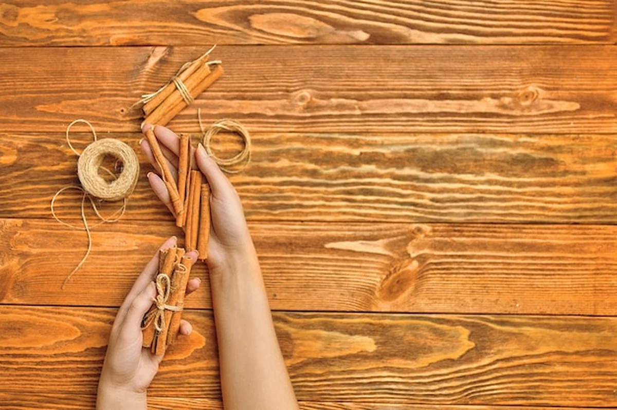 Cynamon w rękach na drewnianym stole