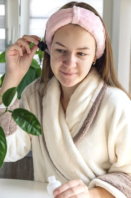 Młoda kobieta stosuje krem do twarzy w pielęgnacji skóry