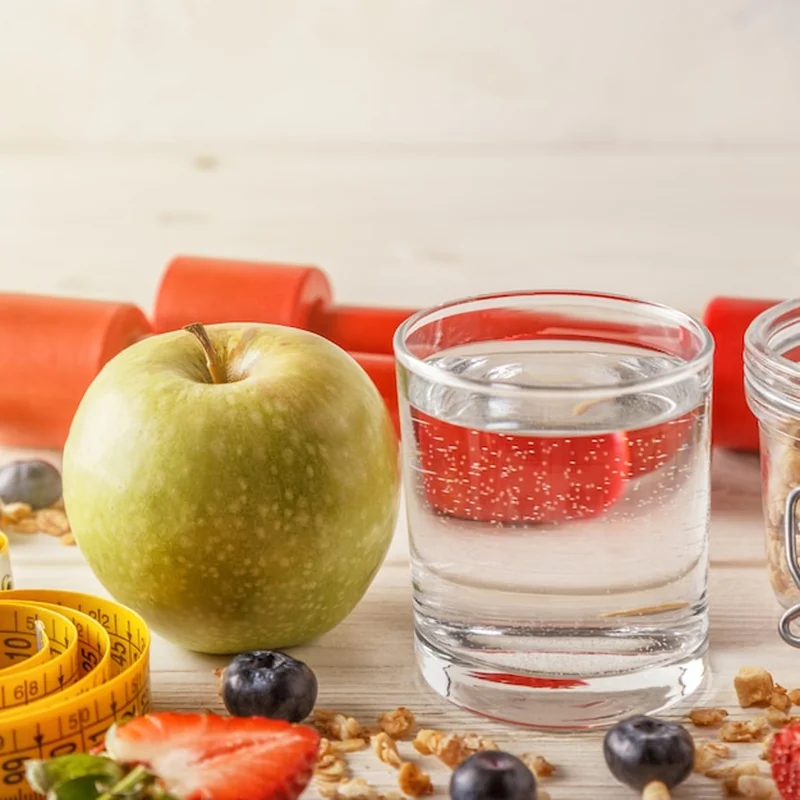 Zdrowe śniadanie z hantlami i miarką na drewnianym tle