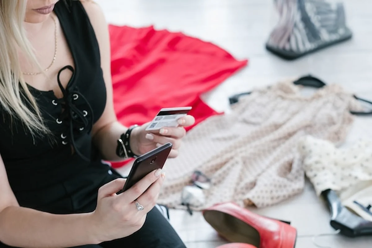 Kobieta trzyma smartfon i kartę kredytową