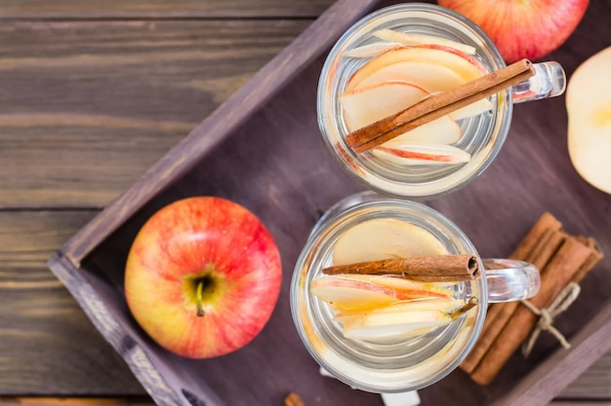 Jabłko i herbata cynamonowa na drewnianym stole