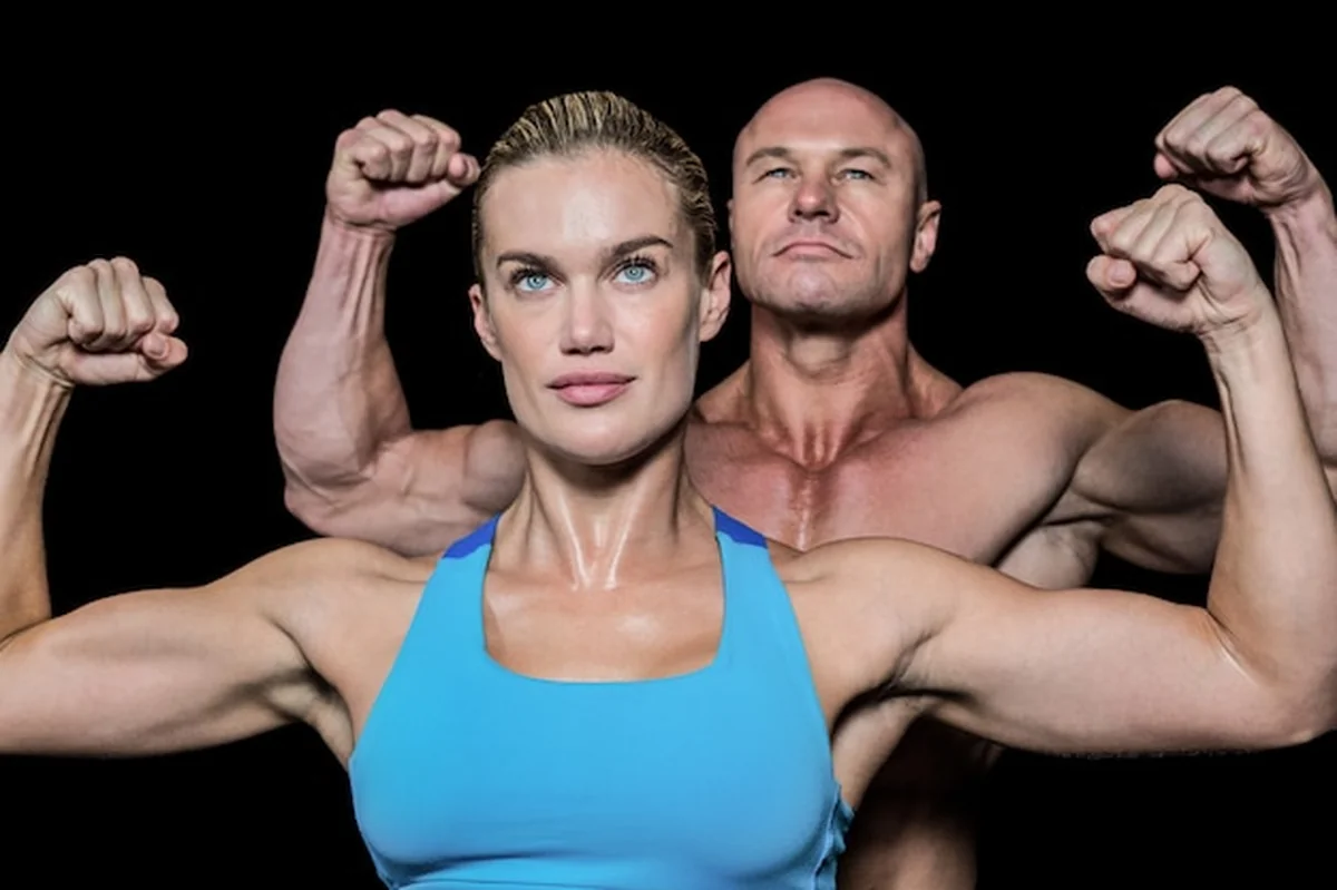 Mężczyzna i kobieta napinają mięśnie przeciw czarnemu tłu