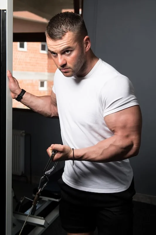 Mężczyzna ćwiczący biceps na siłowni