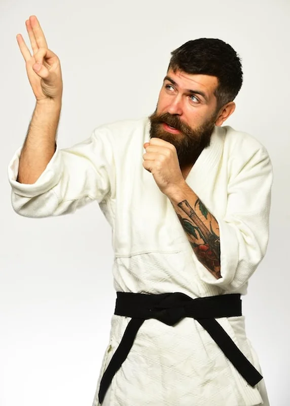 Mistrz Jiu Jitsu z czarnym pasem machający palcami