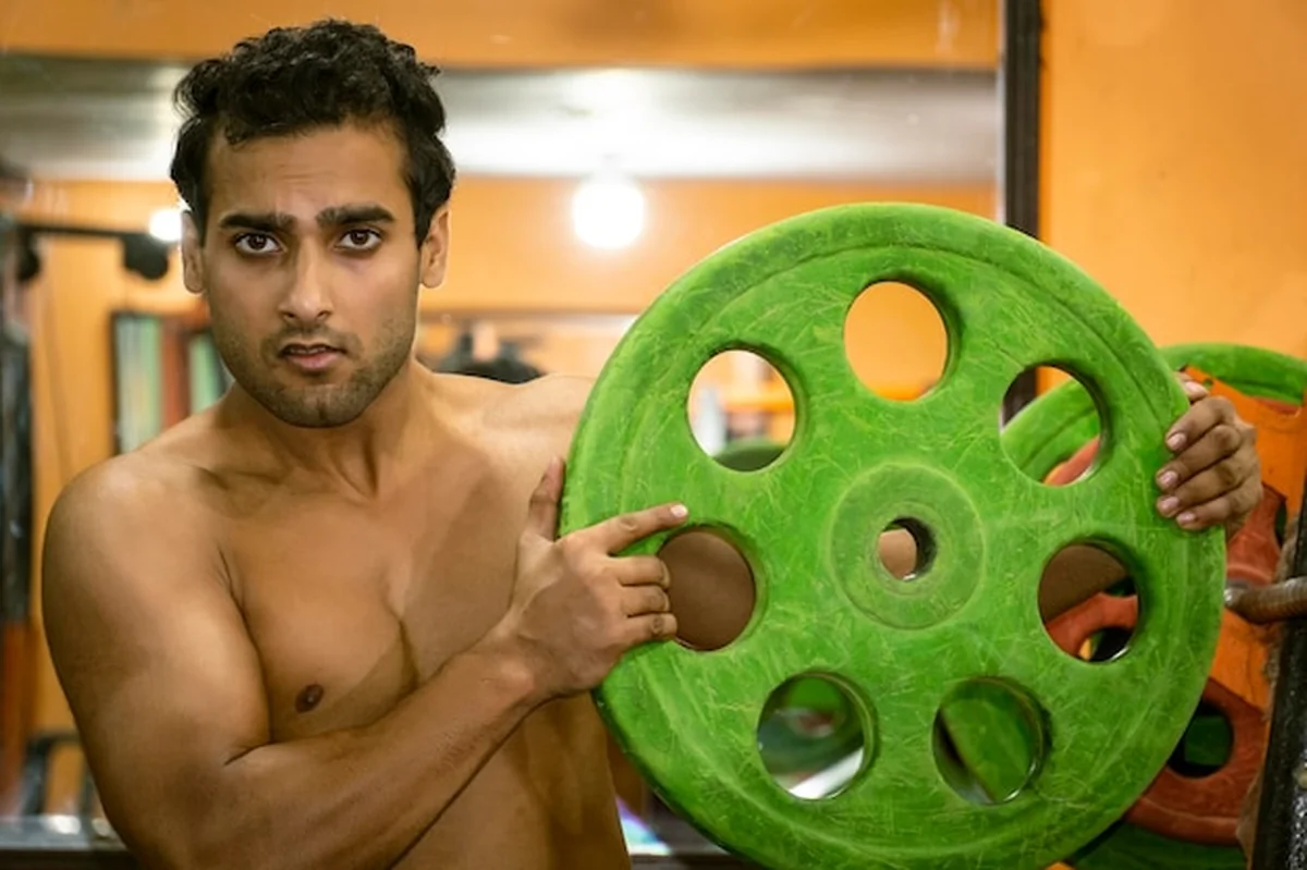 Młody mężczyzna w siłowni z płytą gimnastyczną