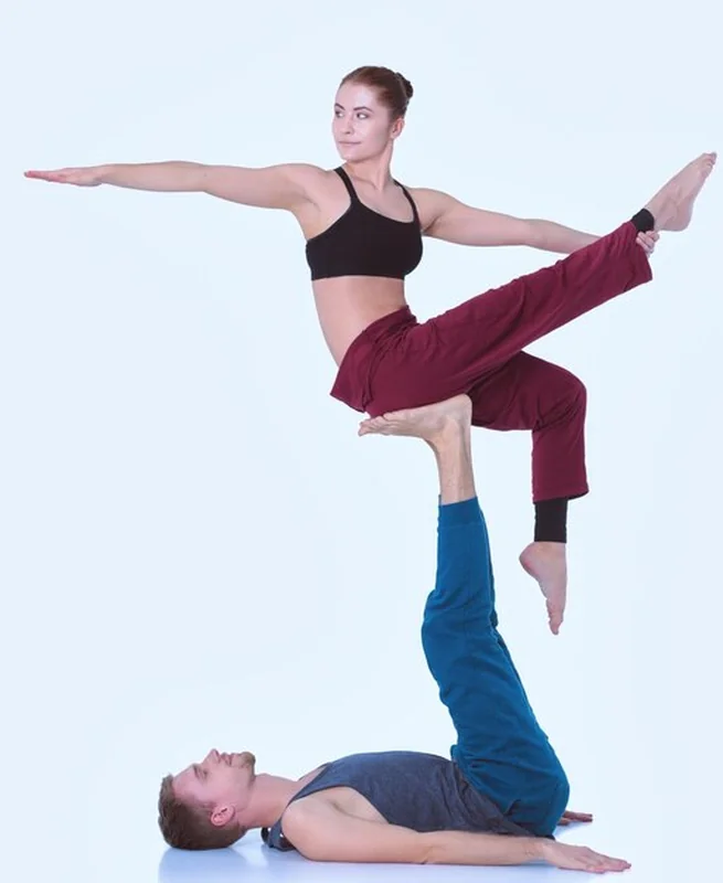 Młoda para atletyczna praktykująca acroyogę. Równoważenie w parze