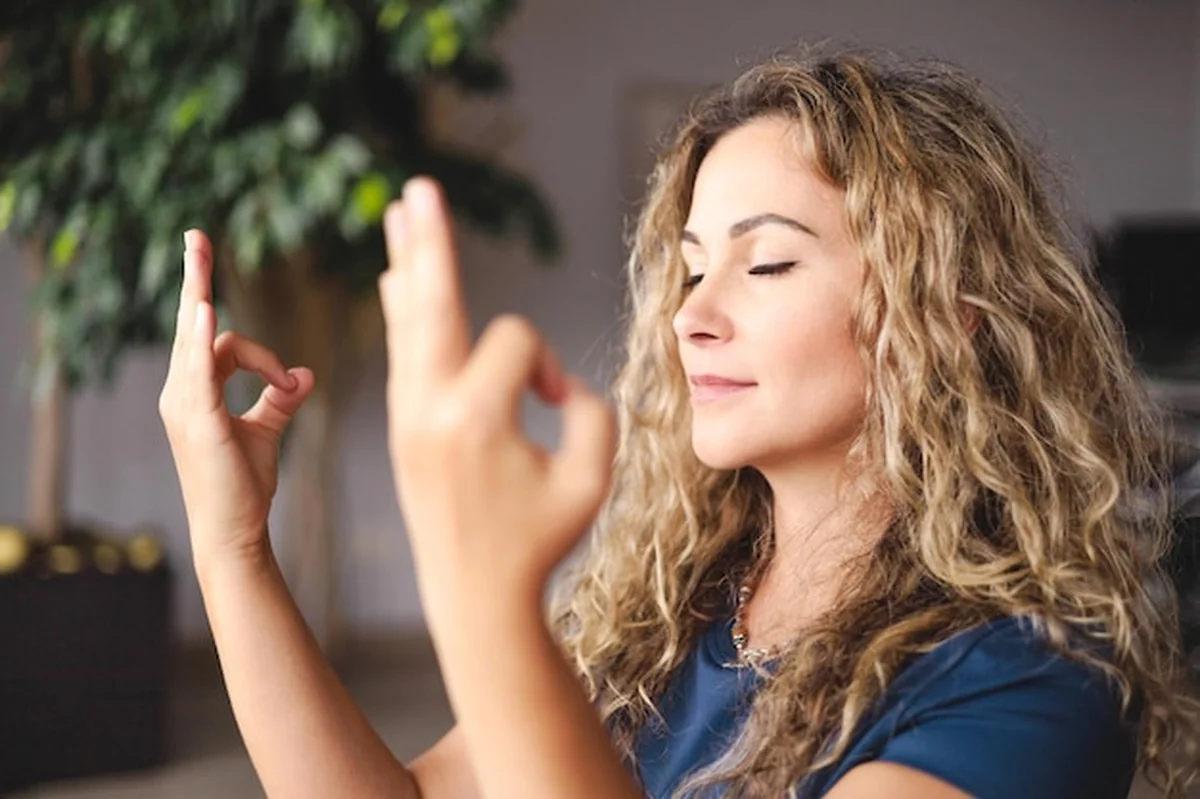 Kobieta praktykująca jogę z rękami w mudrze gyan na zbliżeniu