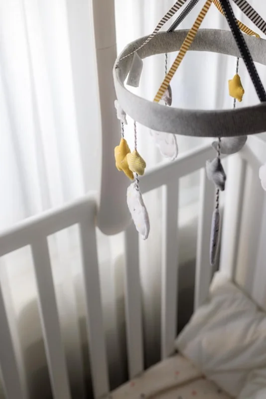 Nowoczesne łóżeczko z mobilnym dzieckiem w pokoju dziecięcym