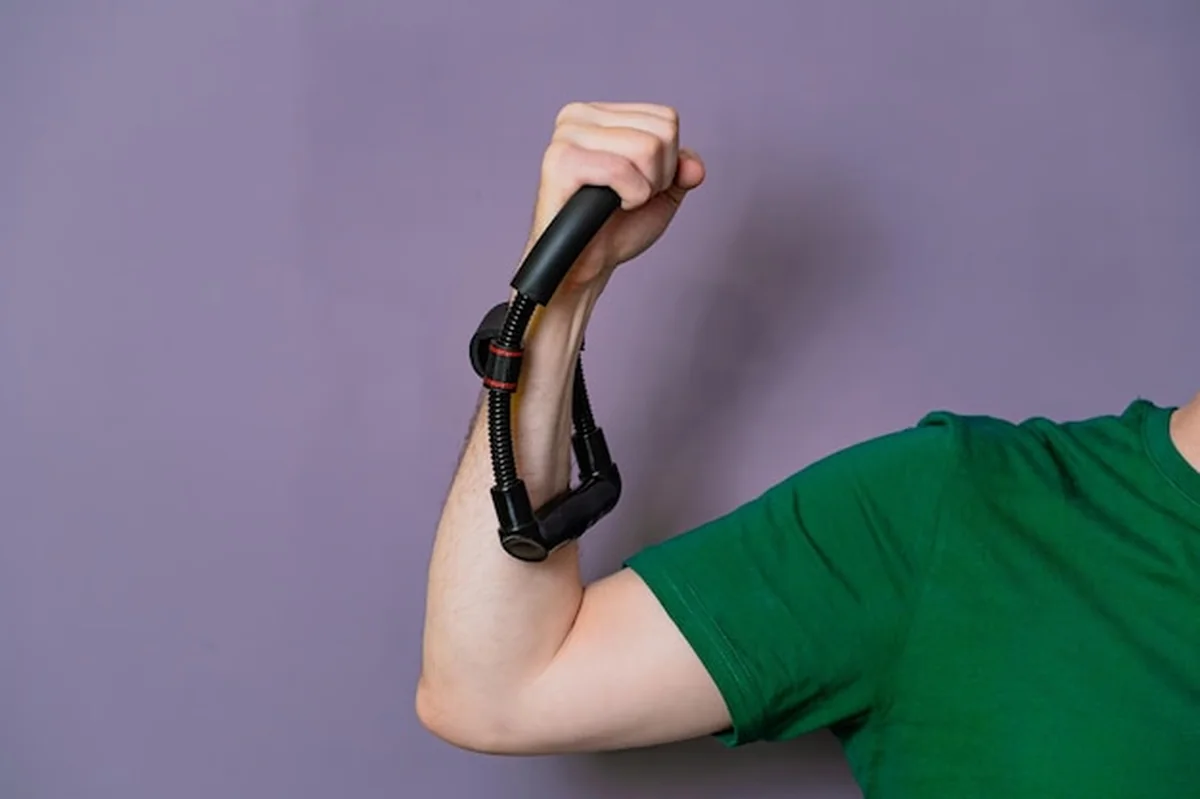 Osoba wykonuje ćwiczenia z pasem oporu do treningu siły ramion