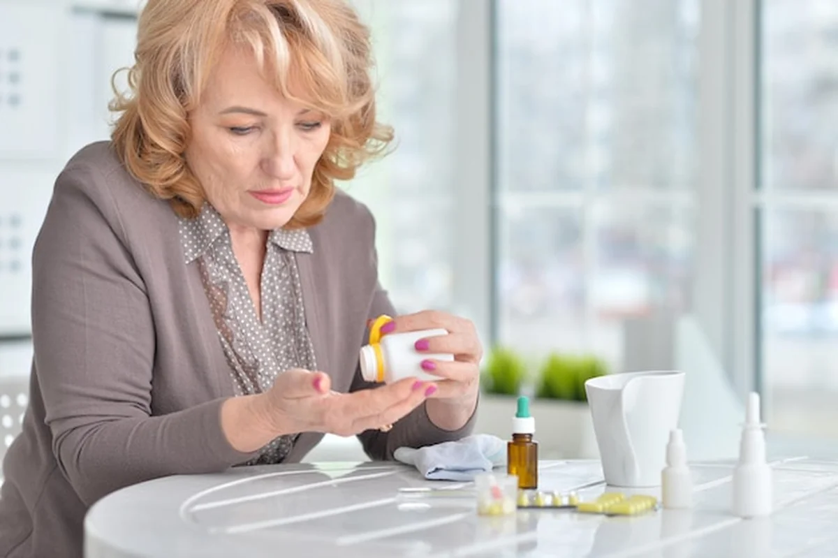 Starsza kobieta zażywająca leki